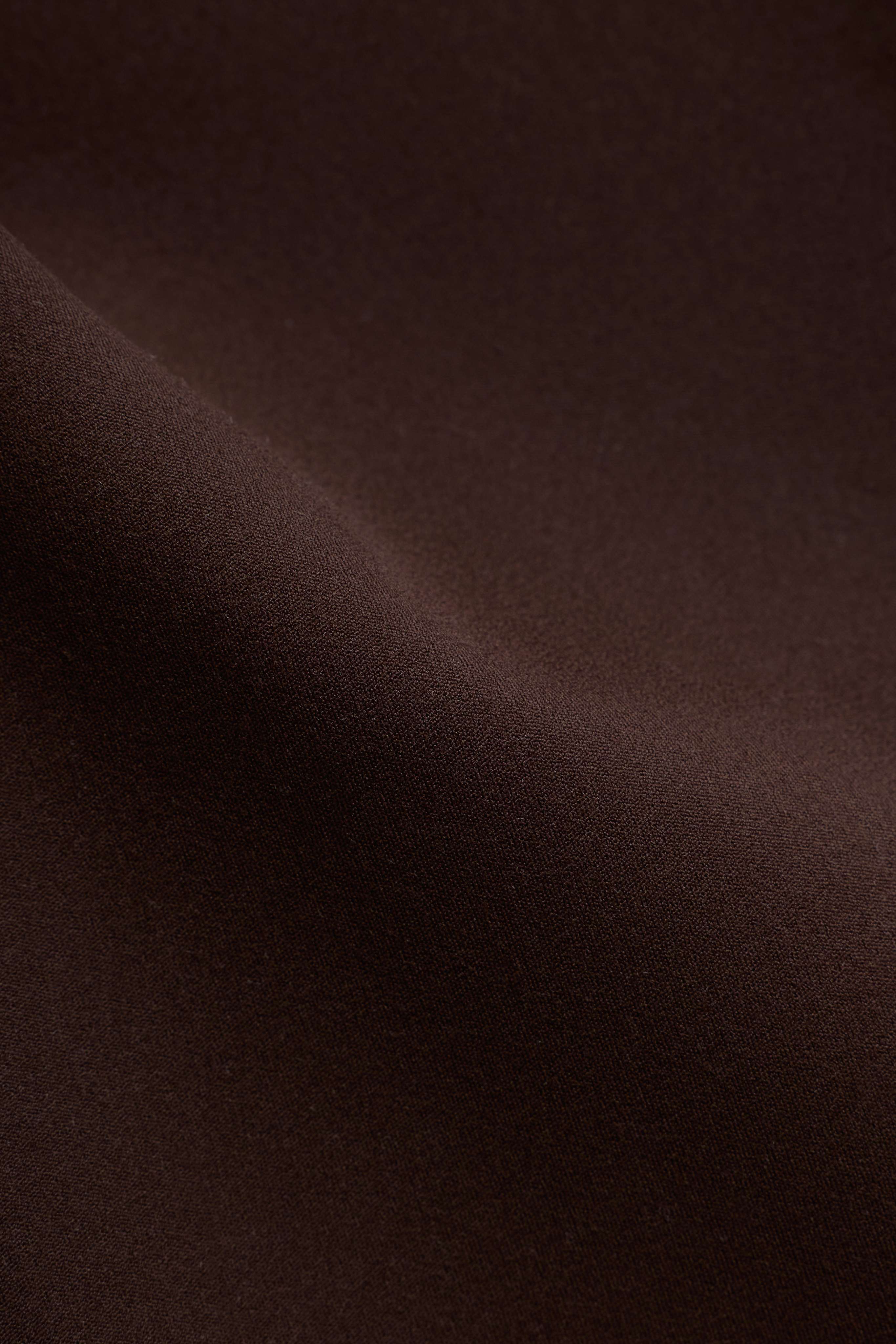 Close-up detail of the espresso brown matte Cloudform fabric on CASPARA yoga pants.